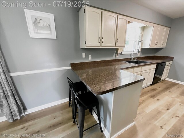 5363 Irish Rd, Grand Blanc, MI 48439 - kitchen featuring dark countertops, a peninsula, light wood-style floors, and a kitchen breakfast bar