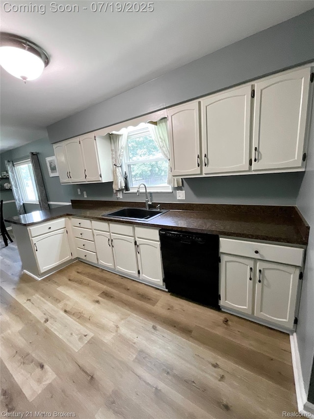 5363 Irish Rd, Grand Blanc, MI 48439 - kitchen with white cabinetry, a peninsula, dark countertops, dishwasher, and light wood-style flooring