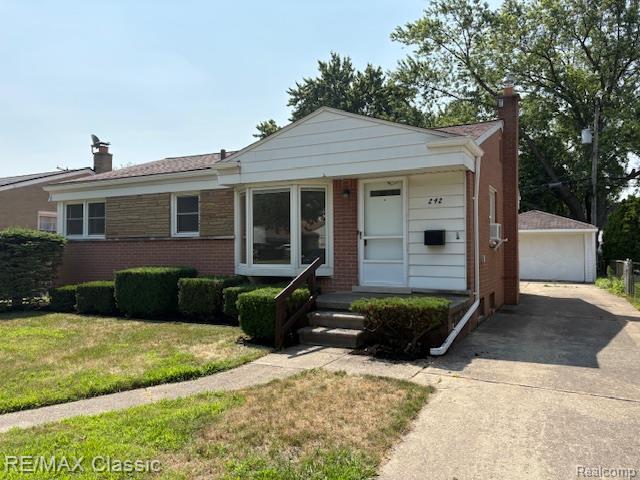 242 E Parker Ave, Madison Heights, MI 48071 - view of front facade with a chimney, brick siding, an outdoor structure, a front yard, and a detached garage