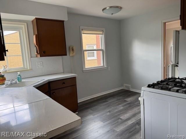 242 E Parker Ave, Madison Heights, MI 48071 - kitchen featuring white range with gas cooktop, light countertops, dark wood finished floors, stainless steel fridge, and dark brown cabinetry