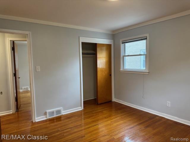 242 E Parker Ave, Madison Heights, MI 48071 - unfurnished bedroom featuring wood finished floors, crown molding, and a closet