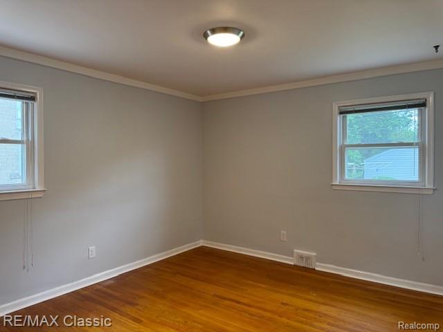 242 E Parker Ave, Madison Heights, MI 48071 - spare room with plenty of natural light, wood finished floors, and ornamental molding