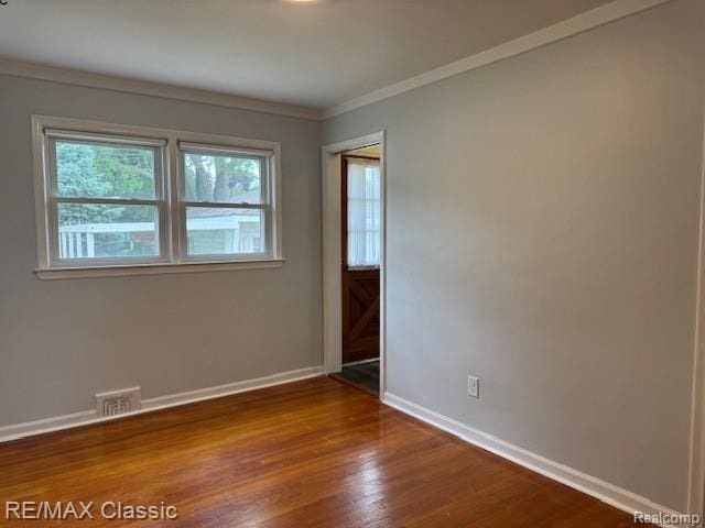 242 E Parker Ave, Madison Heights, MI 48071 - spare room featuring dark wood-style flooring and ornamental molding