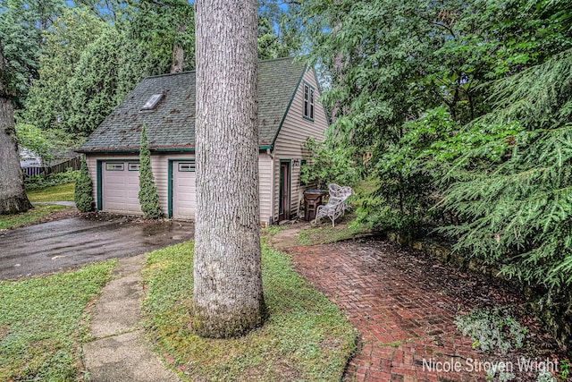 2146 Lansing St SE, Grand Rapids, MI 49506 - view of front of home with a garage, an outbuilding, and roof with shingles