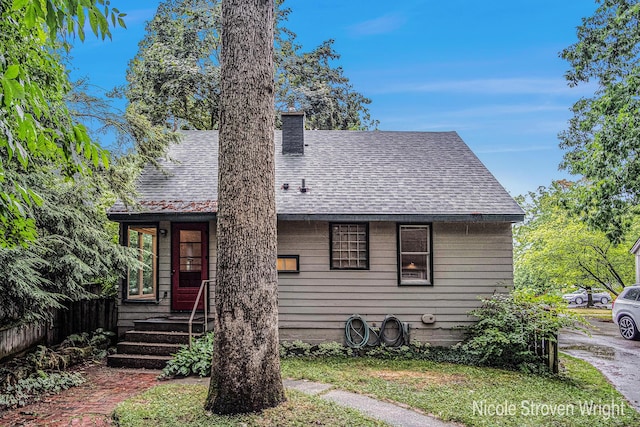 2146 Lansing St SE, Grand Rapids, MI 49506 - view of front of house featuring roof with shingles and a chimney