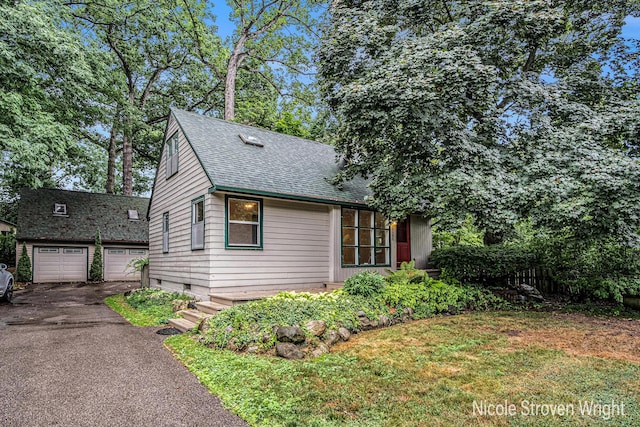 2146 Lansing St SE, Grand Rapids, MI 49506 - view of front of property featuring a shingled roof, asphalt driveway, and an outbuilding