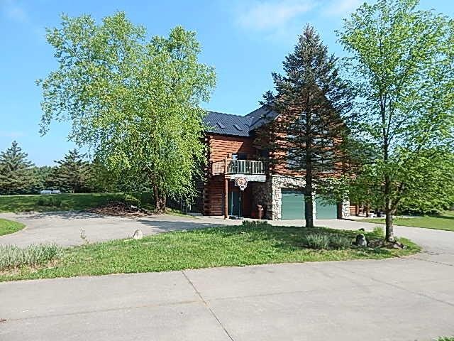 8475 Gurd Rd, Dowling, MI 49050 - view of front of home with concrete driveway, an attached garage, and a metal roof