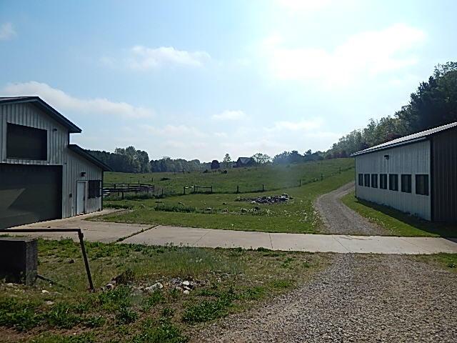 8475 Gurd Rd, Dowling, MI 49050 - view of yard with driveway, a garage, and a rural view