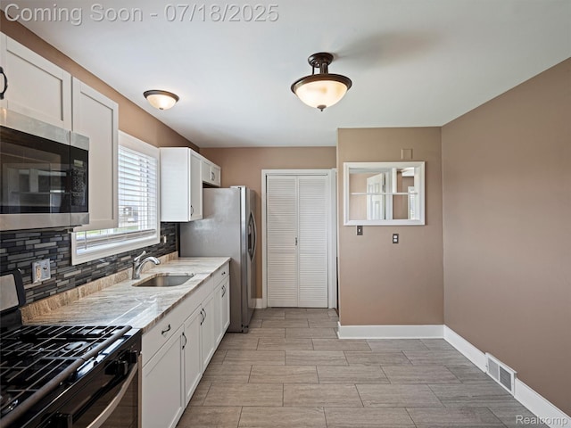 27034 Baldwin Ave, Warren, MI 48092 - kitchen with appliances with stainless steel finishes, decorative backsplash, light stone countertops, and white cabinetry