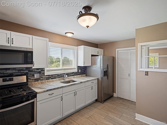 27034 Baldwin Ave, Warren, MI 48092 - kitchen featuring appliances with stainless steel finishes, decorative backsplash, healthy amount of natural light, and white cabinetry