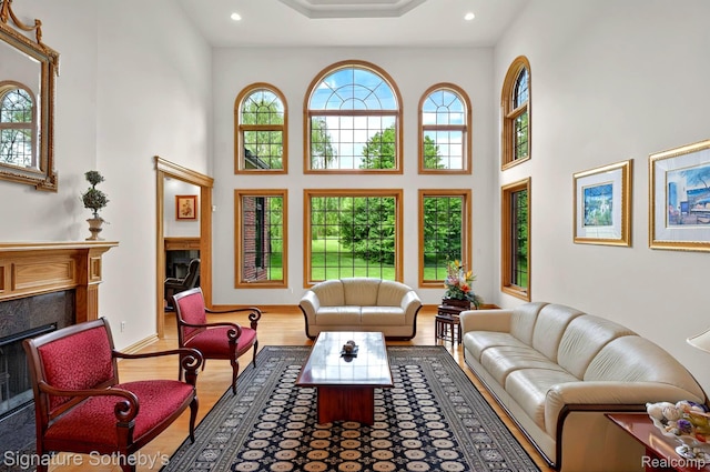 40600 8 Mile Rd, Northville, MI 48167 - living room featuring a high end fireplace, a towering ceiling, wood finished floors, and recessed lighting