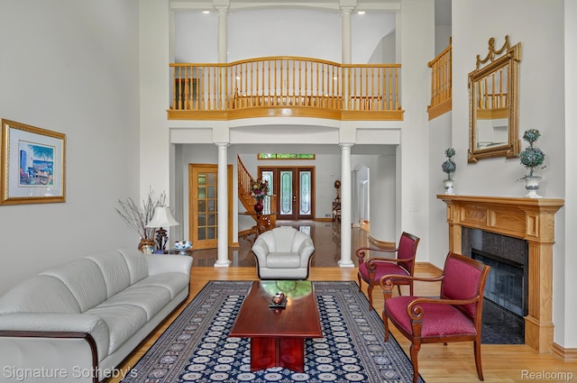 40600 8 Mile Rd, Northville, MI 48167 - living area with ornate columns, wood finished floors, a fireplace with flush hearth, and a high ceiling