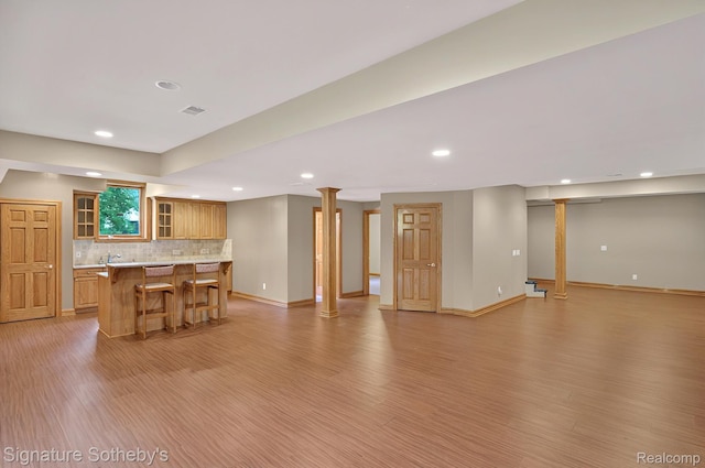 40600 8 Mile Rd, Northville, MI 48167 - kitchen featuring a breakfast bar, light wood-type flooring, recessed lighting, glass insert cabinets, and light countertops