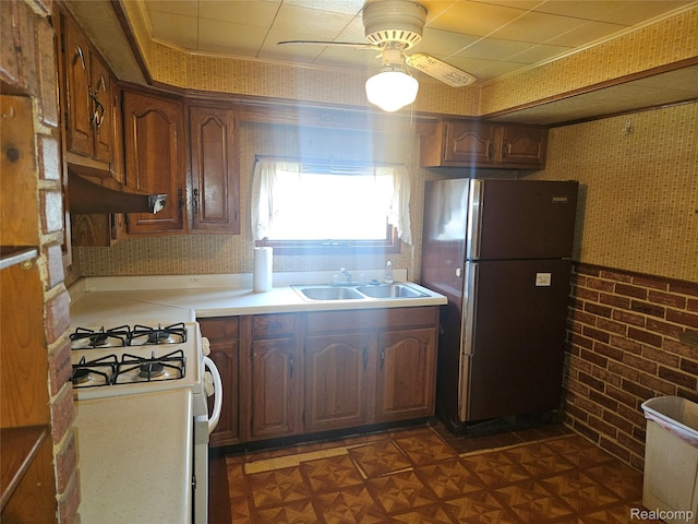 1081 W Parkwood Ave, Flint, MI 48507 - kitchen with freestanding refrigerator, a ceiling fan, wallpapered walls, under cabinet range hood, and white range with gas stovetop