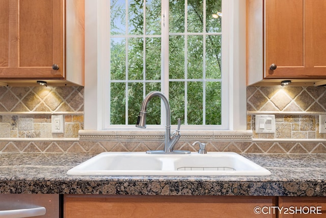 3981 Acadia Dr, Hudsonville, MI 49426 - kitchen with tasteful backsplash, dark countertops, and brown cabinets