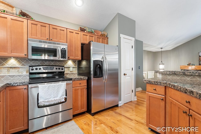 3981 Acadia Dr, Hudsonville, MI 49426 - kitchen featuring appliances with stainless steel finishes, light wood finished floors, backsplash, and tile counters