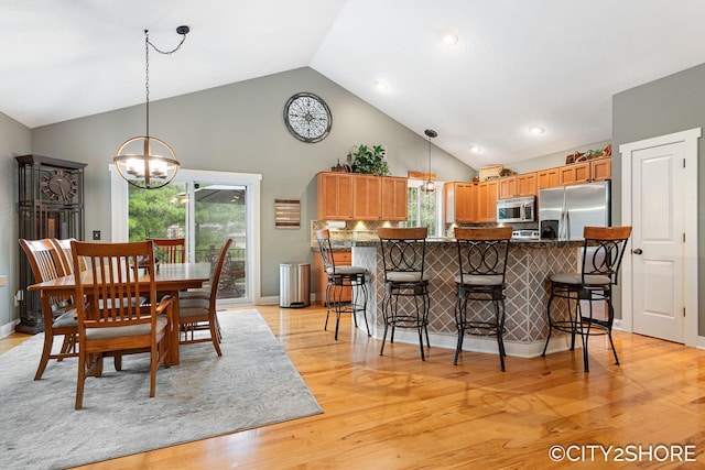 3981 Acadia Dr, Hudsonville, MI 49426 - dining space with high vaulted ceiling, a chandelier, and light wood-type flooring