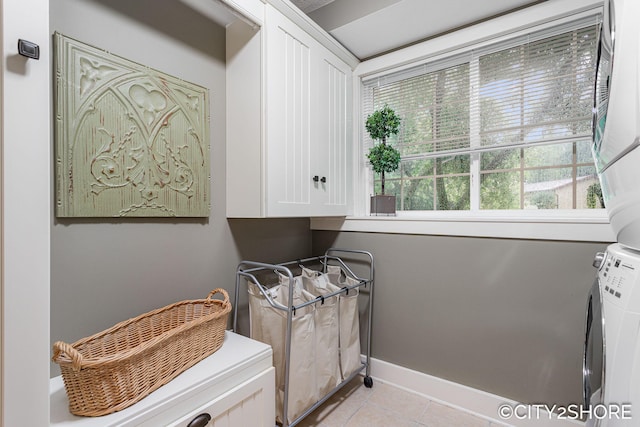 3981 Acadia Dr, Hudsonville, MI 49426 - washroom with stacked washer / drying machine, light tile patterned floors, and cabinet space