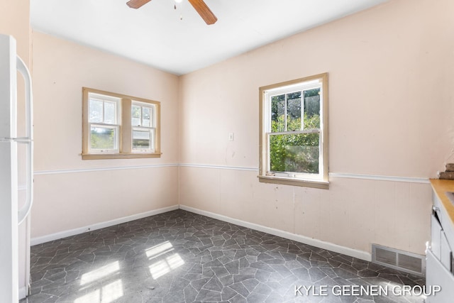 747 State St, Holland, MI 49423 - unfurnished room with stone flooring, ceiling fan, and wainscoting