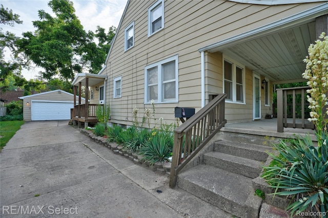 619 Frank St, Flint, MI 48504 - view of side of home with an outdoor structure, covered porch, and a garage