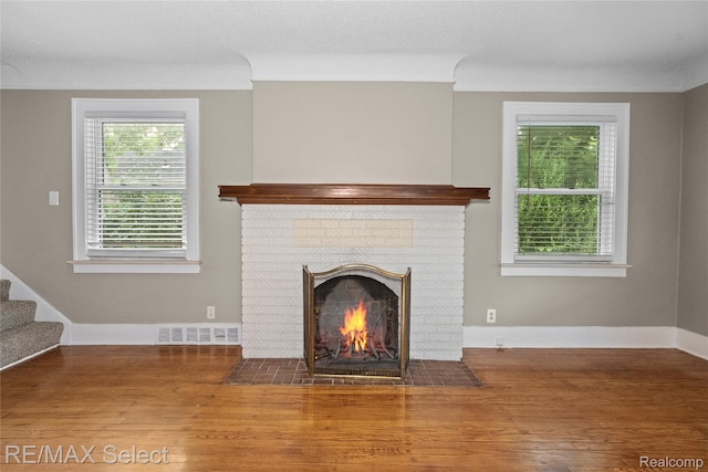 619 Frank St, Flint, MI 48504 - unfurnished living room with wood finished floors, a fireplace, and plenty of natural light
