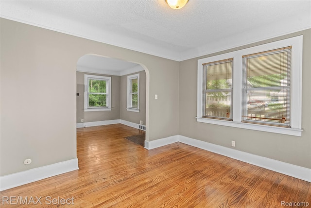619 Frank St, Flint, MI 48504 - spare room with arched walkways, light wood-type flooring, and a textured ceiling