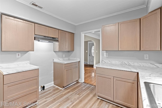 619 Frank St, Flint, MI 48504 - kitchen with light wood-type flooring, arched walkways, ornamental molding, light brown cabinetry, and under cabinet range hood