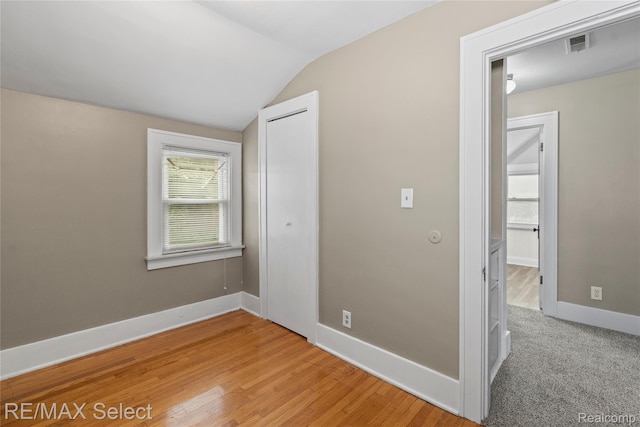 619 Frank St, Flint, MI 48504 - unfurnished bedroom featuring vaulted ceiling, a closet, and light wood-style flooring
