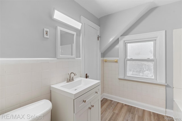 619 Frank St, Flint, MI 48504 - bathroom featuring tile walls, vanity, and wood finished floors
