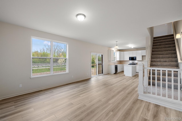 21008 Campolina Dr, South Lyon, MI 48178 - unfurnished living room featuring light wood-style flooring and stairway