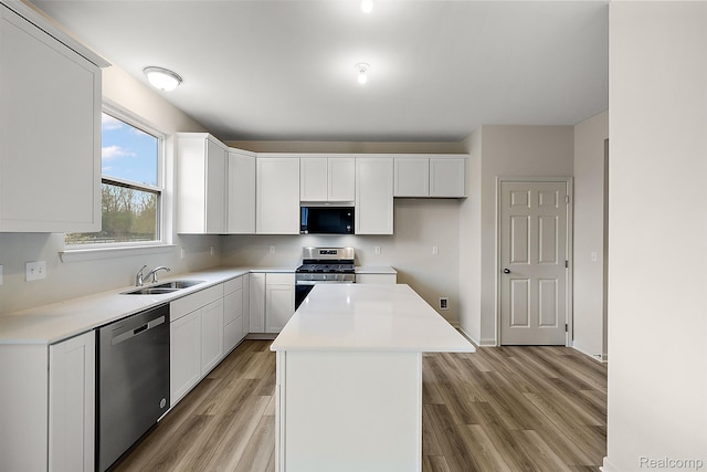 21008 Campolina Dr, South Lyon, MI 48178 - kitchen featuring stainless steel appliances, light wood finished floors, a center island, white cabinets, and light countertops