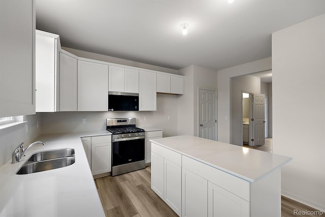 21008 Campolina Dr, South Lyon, MI 48178 - kitchen with appliances with stainless steel finishes, light wood finished floors, light countertops, white cabinetry, and a kitchen island