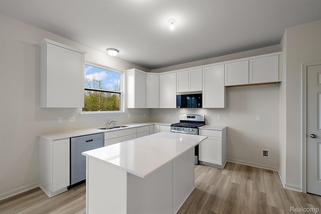 21008 Campolina Dr, South Lyon, MI 48178 - kitchen with appliances with stainless steel finishes, light wood-style flooring, white cabinetry, and a center island