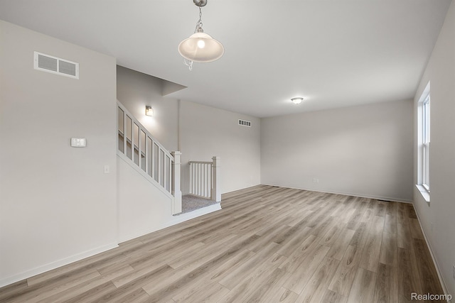 21008 Campolina Dr, South Lyon, MI 48178 - unfurnished living room with light wood-style floors, plenty of natural light, and stairs