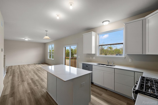 21008 Campolina Dr, South Lyon, MI 48178 - kitchen featuring stove, wood finished floors, a kitchen island, light countertops, and pendant lighting