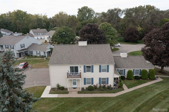 3091 Oakridge Ct, Lake Orion, MI 48360 - view of front of house with a balcony, a chimney, a front lawn, and roof with shingles