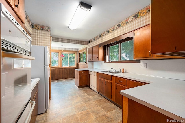1615 W Genesee St, Lapeer, MI 48446 - kitchen with brown cabinets, light countertops, white appliances, stone finish floors, and wallpapered walls
