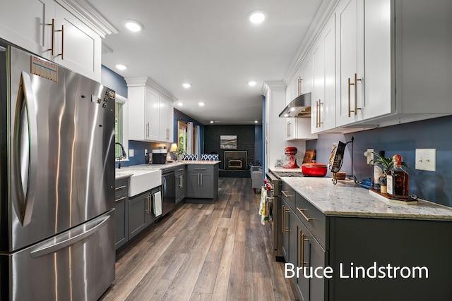 15520 157th Ave, Big Rapids, MI 49307 - kitchen featuring stainless steel appliances, wall chimney range hood, white cabinets, light stone countertops, and dark wood-style floors