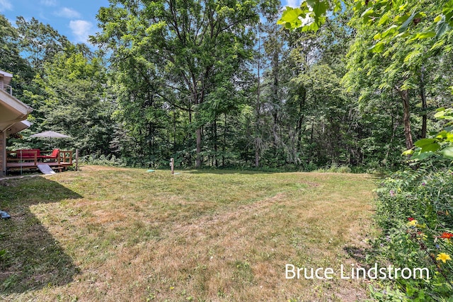 15520 157th Ave, Big Rapids, MI 49307 - view of green lawn featuring a deck and a view of trees