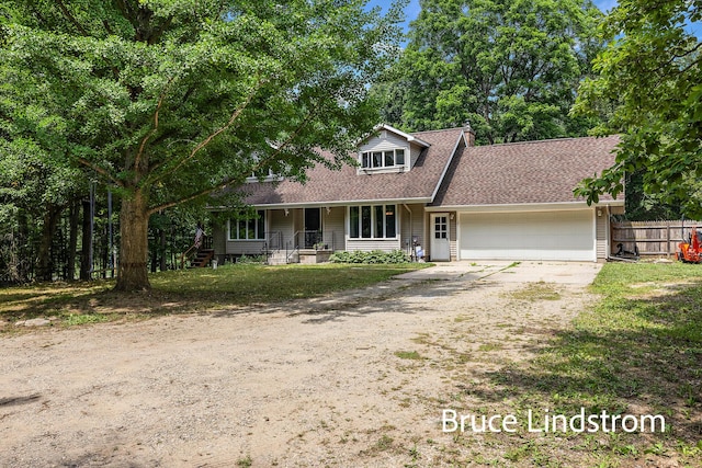 15520 157th Ave, Big Rapids, MI 49307 - view of front facade featuring dirt driveway, a garage, a porch, and roof with shingles
