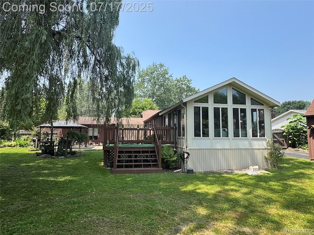 2185 Roslyn Ave, Flint, MI 48532 - back of house with a deck, a yard, and a sunroom