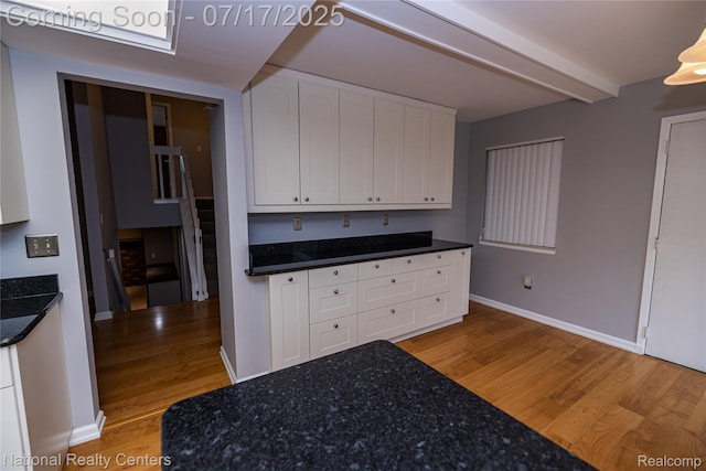 625 Ten Point Dr, Rochester Hills, MI 48309 - kitchen with light wood finished floors, white cabinets, beamed ceiling, and dark stone countertops