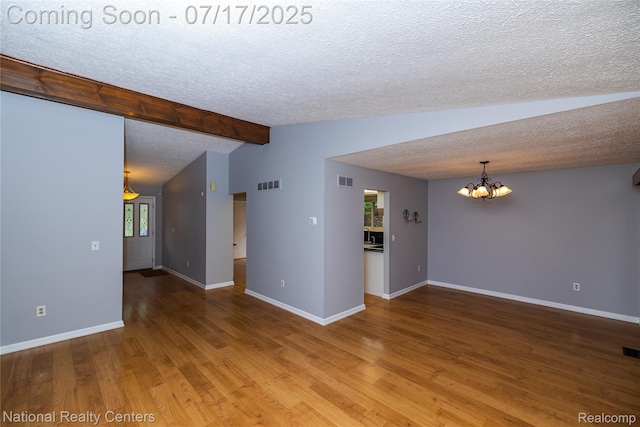 625 Ten Point Dr, Rochester Hills, MI 48309 - spare room with a textured ceiling, a chandelier, and wood finished floors