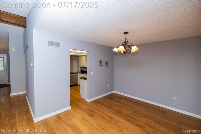 625 Ten Point Dr, Rochester Hills, MI 48309 - spare room with a chandelier, light wood-type flooring, and a textured ceiling