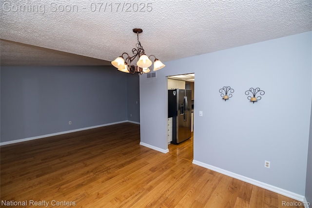 625 Ten Point Dr, Rochester Hills, MI 48309 - unfurnished room featuring a chandelier, light wood finished floors, and a textured ceiling