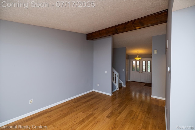 625 Ten Point Dr, Rochester Hills, MI 48309 - empty room with stairs, wood finished floors, a textured ceiling, and beamed ceiling