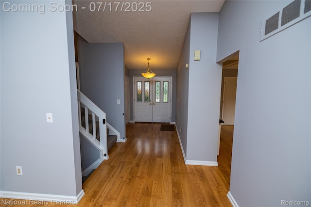 625 Ten Point Dr, Rochester Hills, MI 48309 - foyer featuring light wood-style flooring, stairs, and a textured ceiling