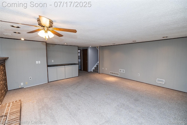 625 Ten Point Dr, Rochester Hills, MI 48309 - unfurnished living room with stairs, ceiling fan, carpet floors, and a textured ceiling