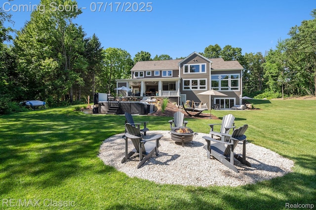 7171 Lucy Dr, Dexter, MI 48130 - back of house with a hot tub, a fire pit, a yard, and a wooden deck