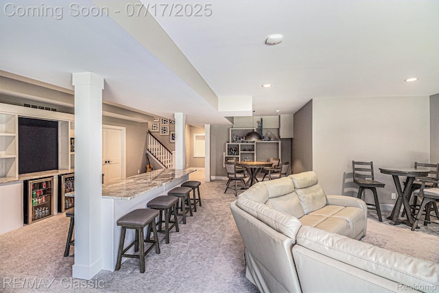 7171 Lucy Dr, Dexter, MI 48130 - living room with light colored carpet, wine cooler, stairs, recessed lighting, and bar area